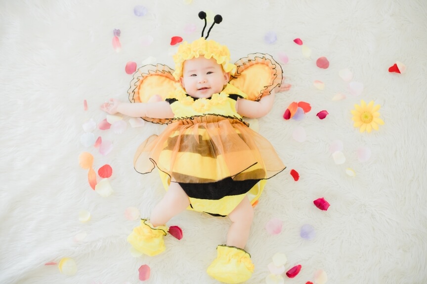 ハチの衣裳を着て笑う赤ちゃんのイメージ