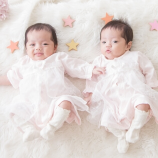白いフリルの衣裳を着た双子の赤ちゃんのイメージ（サムネイル）