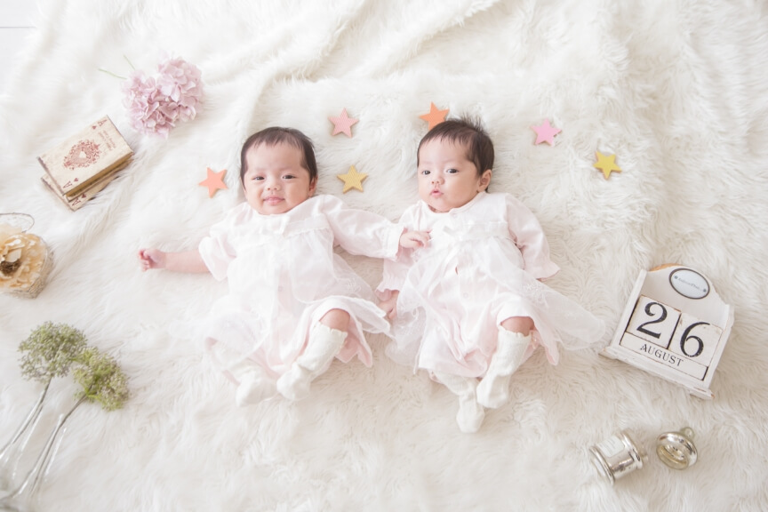 白いフリルの衣裳を着た双子の赤ちゃんのイメージ