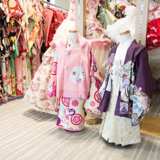 沢山の衣装があるスペースに、お子様用のピンクの着物と紫の羽織の袴が飾ってある風景