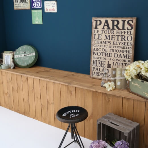 白い床と紺色の壁の空間に、木製の台とオシャレな小物が置いてあるスタジオ