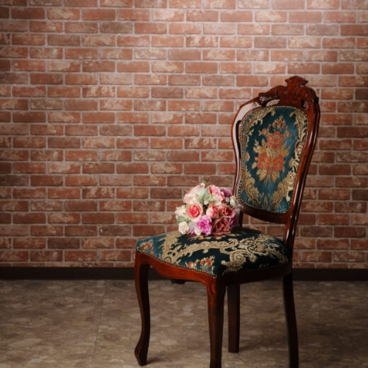 レンガの壁の空間に洋風の品がある椅子が置いてあるスタジオ