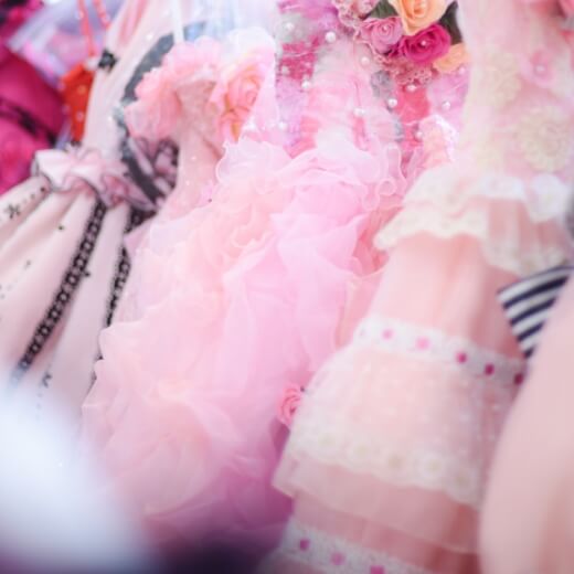 ピンクレースがついたの様々な衣装ドレスが並べられている風景