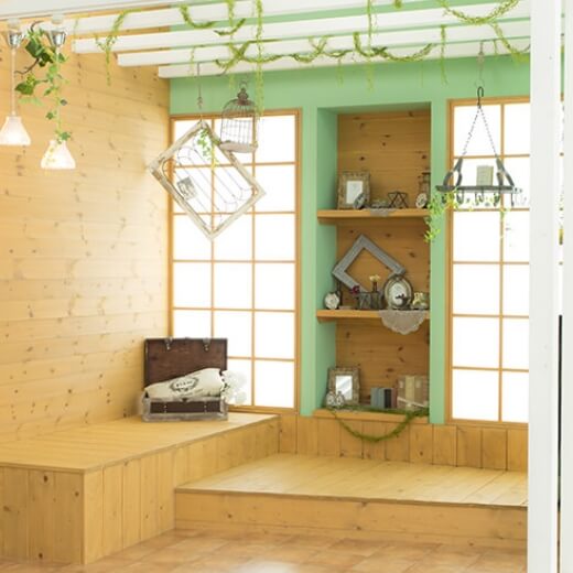 ウッドデッキと明るい緑の壁に光が差し込む自然なスタジオ