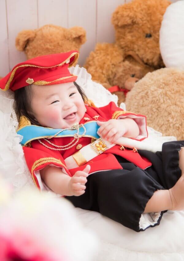 赤い制服風の衣装にニコニコ笑顔の赤ちゃんのイメージ